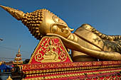 Vientiane, Laos - Pha That Luang, large gilded reclining Buddha within the temple area. 